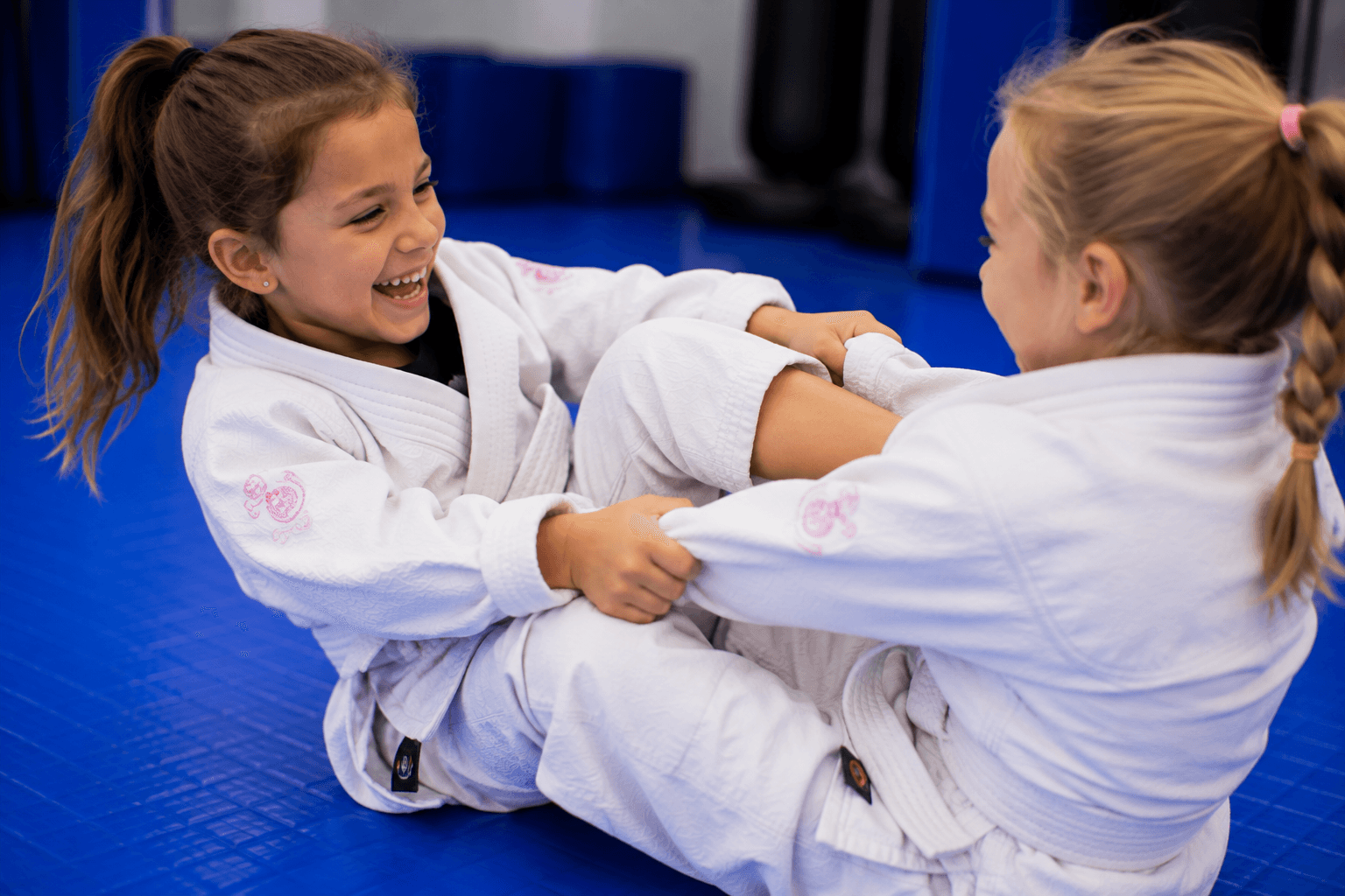 Coach holding focus mitts for a young student at Master Pete's BJJ Academy